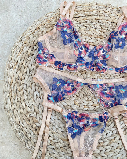 Ensemble de lingerie rose en dentelle fleurie 3 pièces. Soutien-gorge, culotte et porte-jarretelles assortie pour un look sophistiqué et sensuel. 